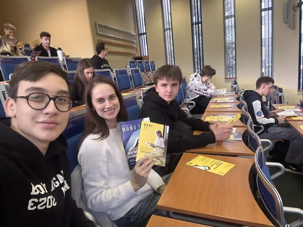 Студенти в аудиторії тримають буклети університету