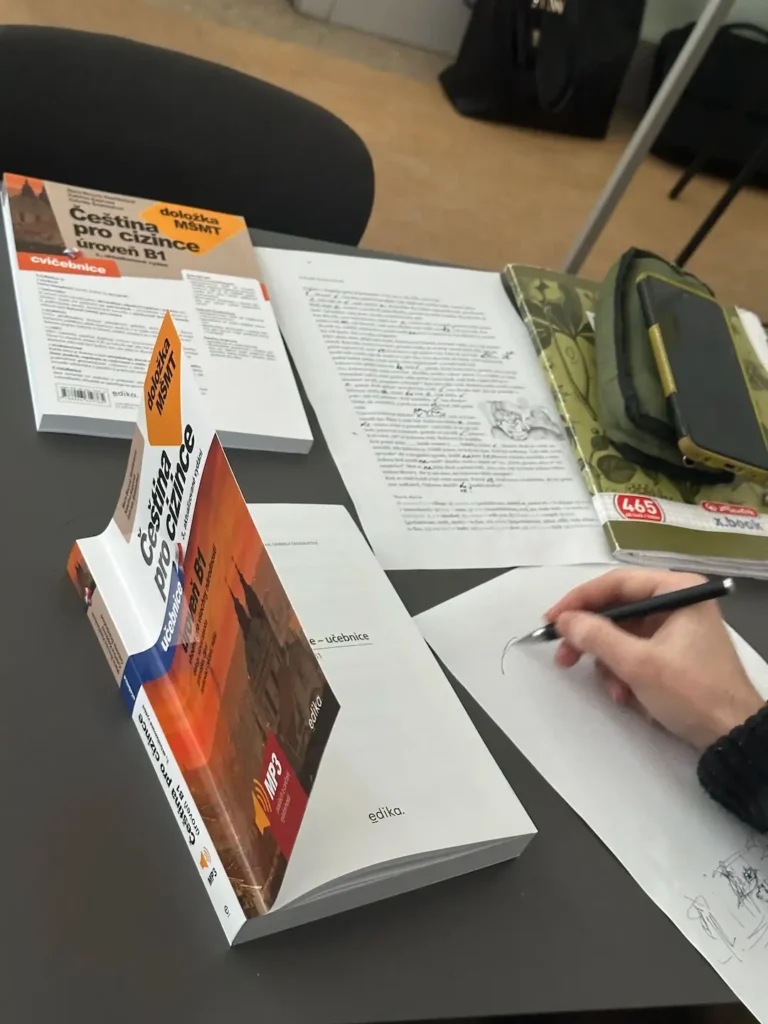 підручник чеської мови рівня B1 і студент під час підготовки до вступу